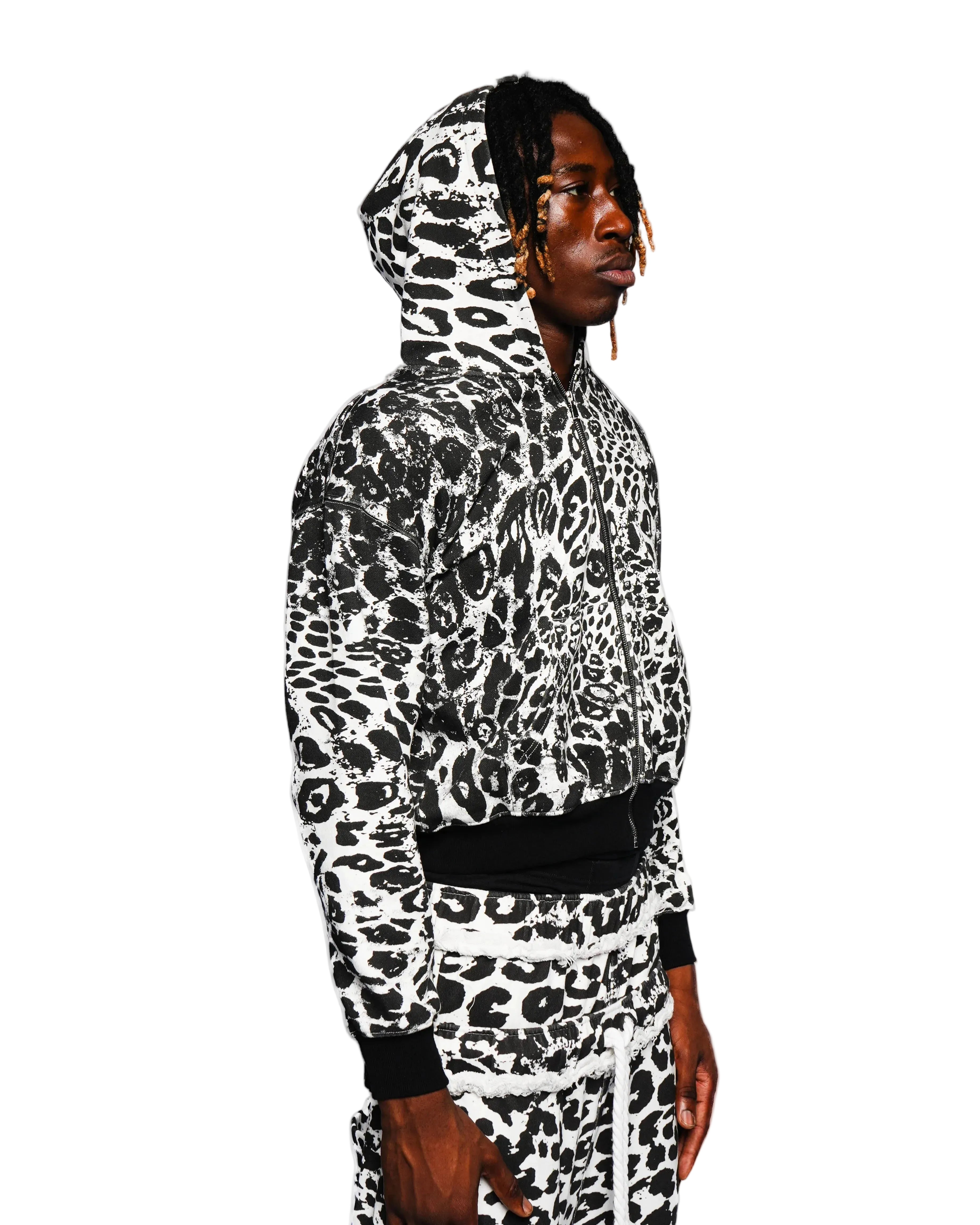 Person wearing a black and white leopard print hoodie on a white background